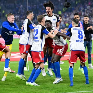 Die HSV-Profis feiern nach dem Sieg über Schalke vor der Nordtribüne