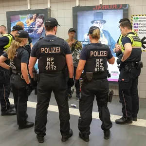Bundespolizisten und Sicherheitskräfte der Deutschen Bahn kontrollieren einen Mann.