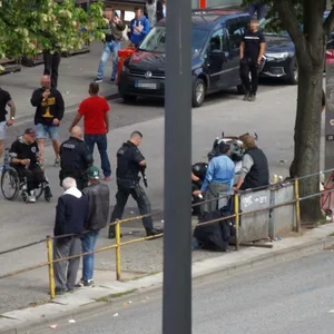 Polizisten haben den Mann überwältigt. Daneben: ein Polizist mit Maschinenpistole.