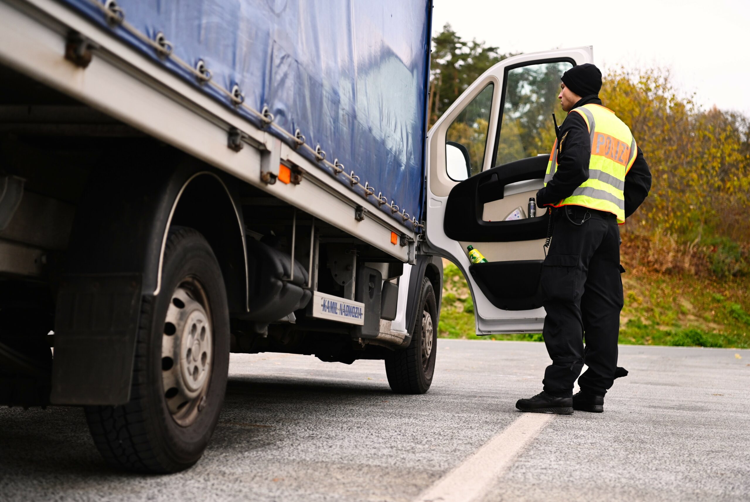 Ein Polizist kontrolliert einen Lkw (Symbolbild).