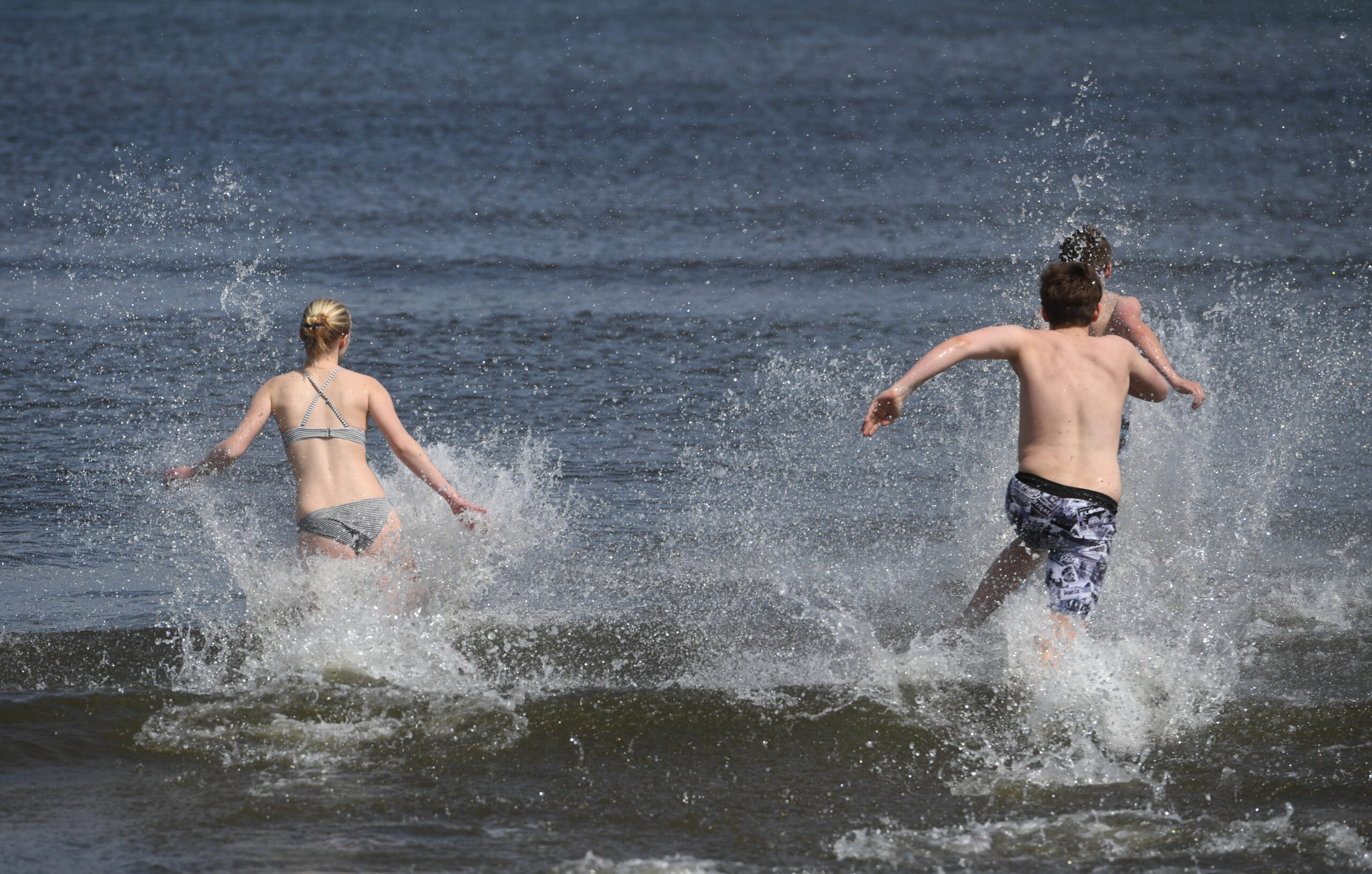 Junge Leute laufen in die Ostsee. Gerade wurde eine Infektion mit sogenannten Vibrionen nachgewiesen. (Symbolbild)