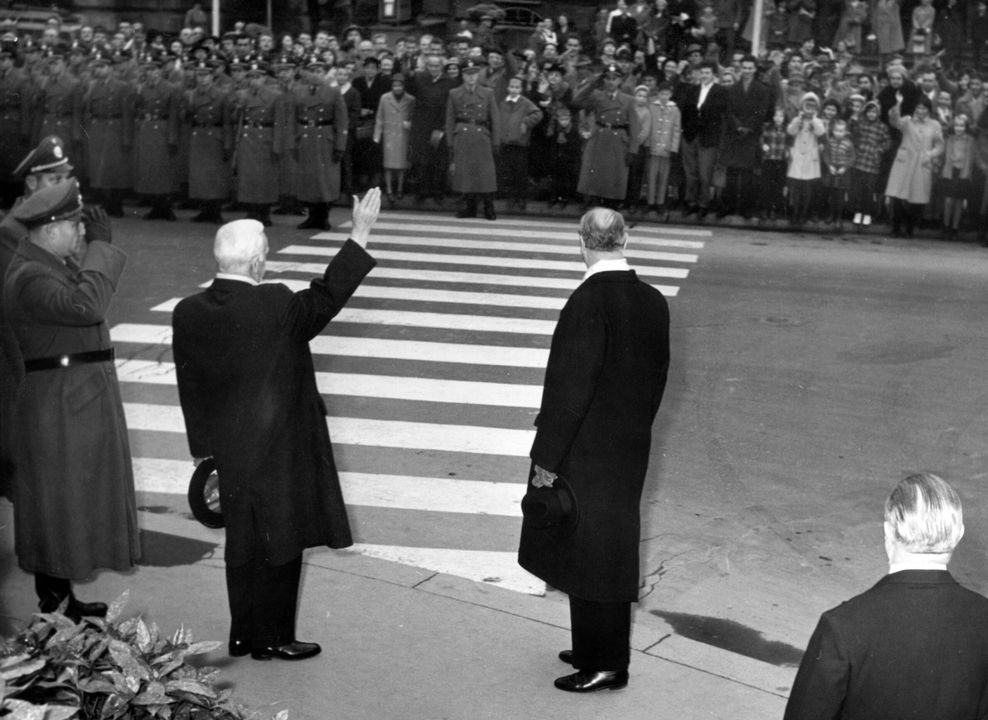 Bundespräsident Heinrich Lübke (CDU, 3.v.l.) steht 1959 an einem der ersten deutschen Zebrastreifen in Wiesbaden und winkt den Menschen zu. (Archivbild)