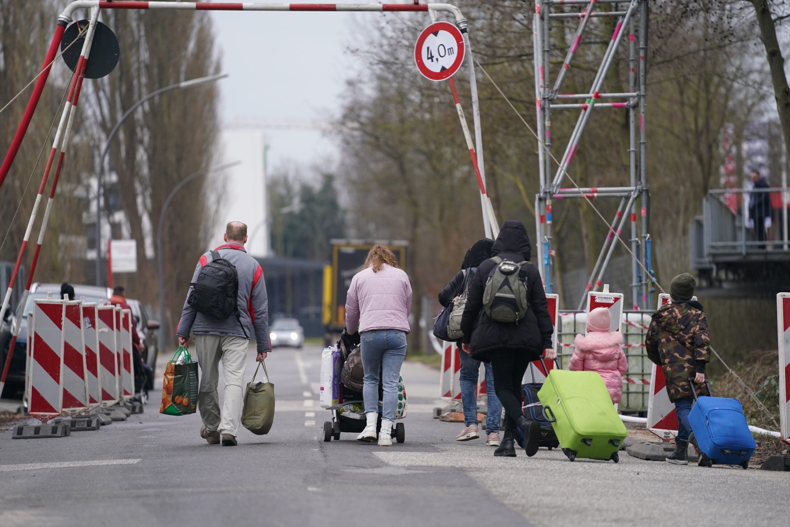 Ukrainische Flüchtlinge verlassen mit ihrem Gepäck die Flüchtlingsunterkunft im ehemaligen Fegro Großmarkt im Stadtteil Harburg