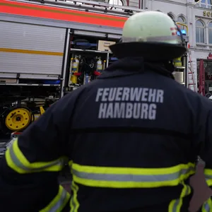 Einsatzkräfte der Feuerwehr stehen während eines Brands vor einem Theatergebäude auf der Reeperbahn. (Symbolbild)
