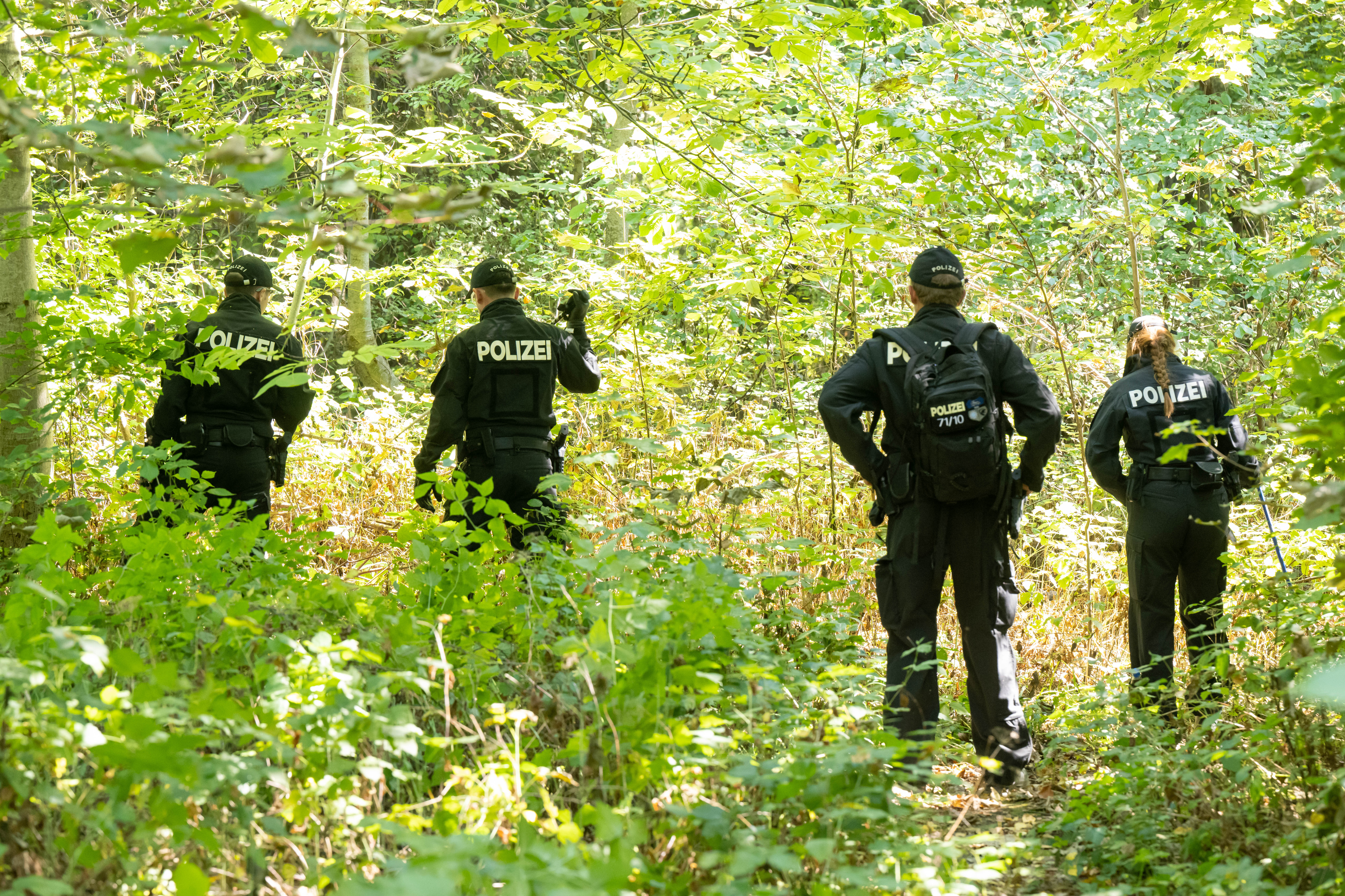 Polizisten durchsuchen nach dem Fund der Leiche der Doppelgängerin in Ingolstadt ein Waldstück nach Spuren und Gegenständen. (Archivbild)