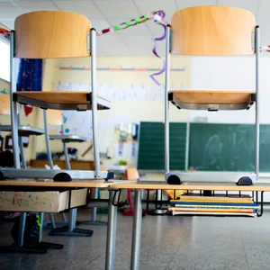 Stühle stehen nach Schulschluss auf den Tischen in einem Unterrichtsraum einer Grundschule. (Symbolbild)