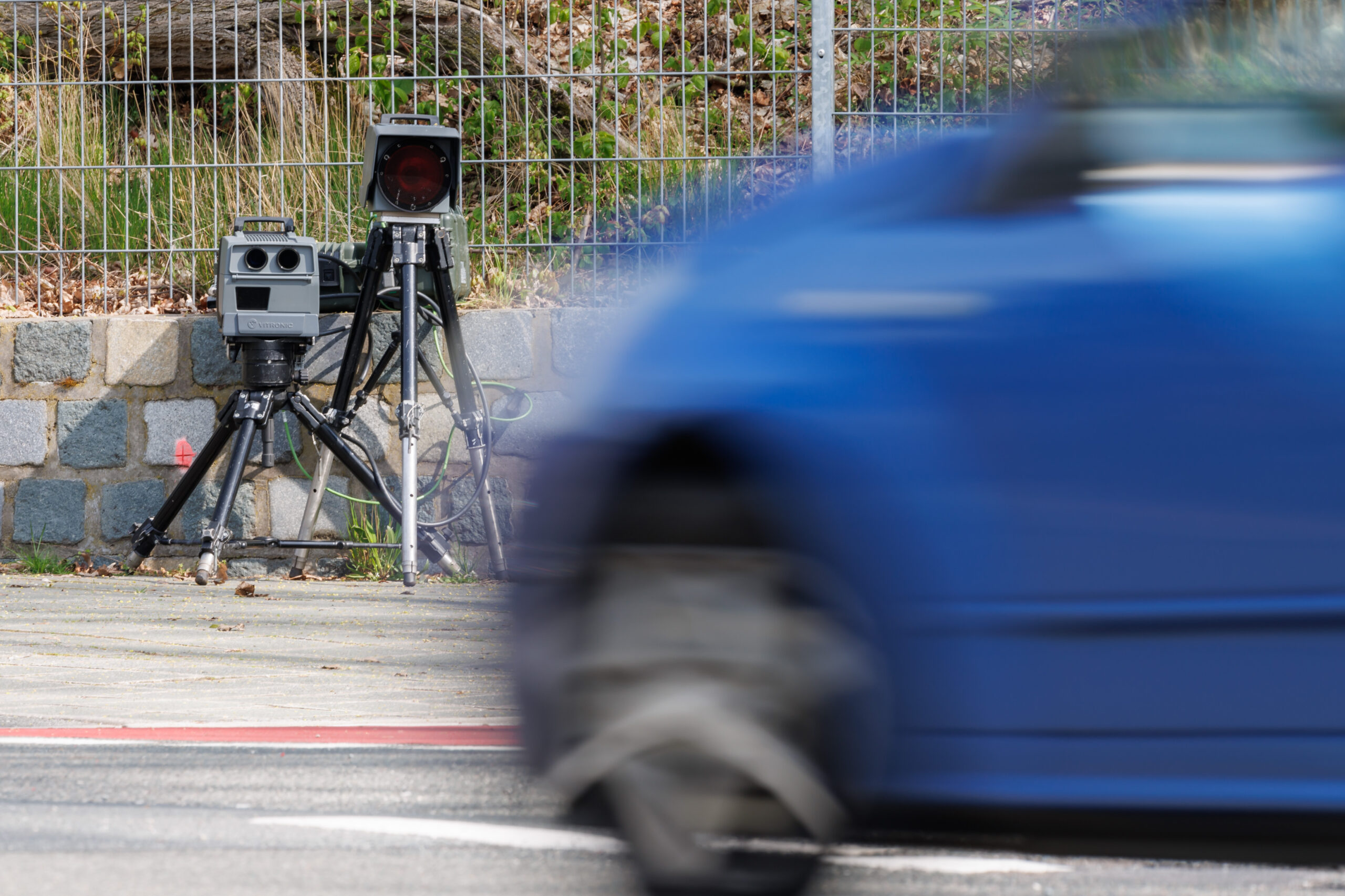 Ein Auto fährt an einem Blitzer vorbei.