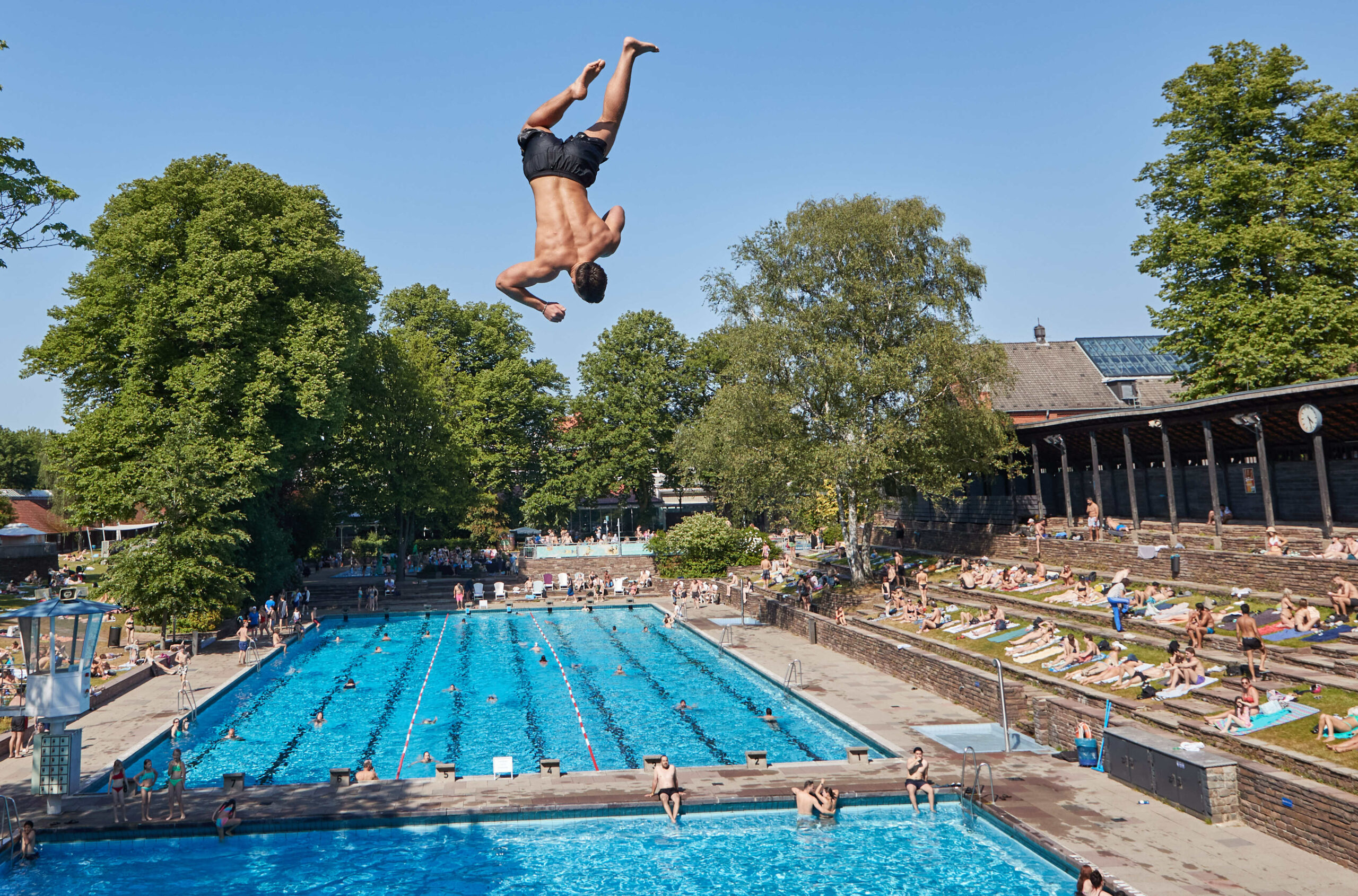 Ein Mann springt vom Zehnmeter Turm in das Becken im Sommerfreibad Kaifu-Bad. (Archivbild)