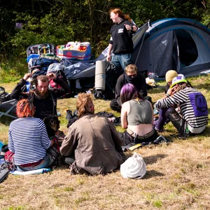Punks sitzen in Tinnum auf der Wiese eines Protestcamps.