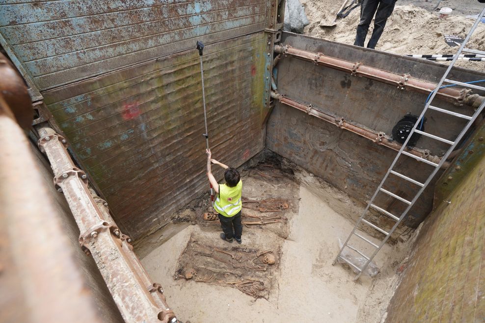 Archäologinnen vermessen die Funde in der Grabungsstelle.