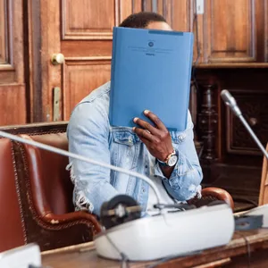 Ibrahim T. im Gerichtssaal, er verbirgt sein Gesicht hinter einem Aktendeckel