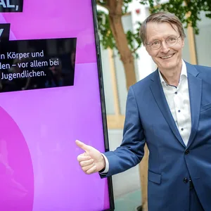 Karl Lauterbach (SPD), Bundesminister für Gesundheit, steht zu Beginn der Pressekonferenz zum Cannabis-Gesetz neben einer Werbeanzeige seines Ministeriums zum Cannabis-Konsum.