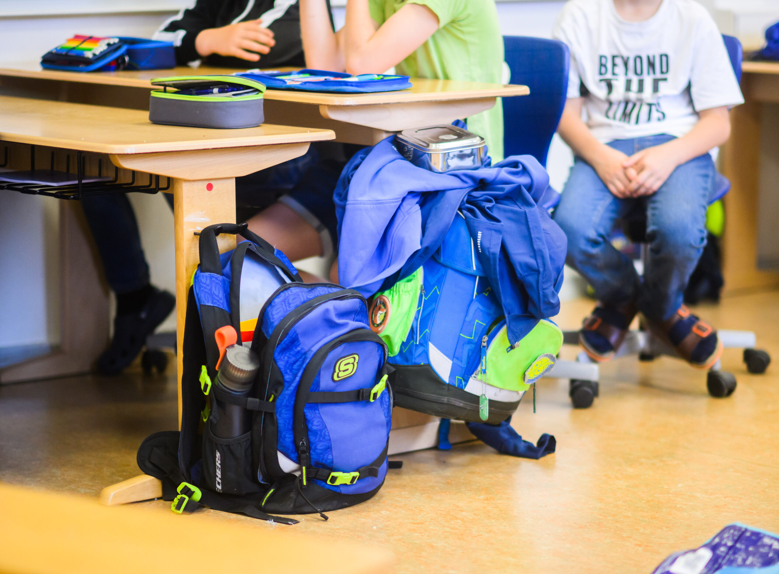 Zwei Schulranzen stehen in einem Klassenzimmer.