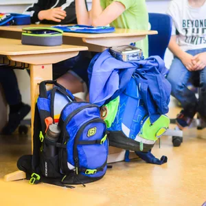 Zwei Schulranzen stehen in einem Klassenzimmer.