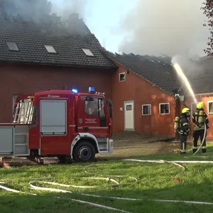 Einsatzkräfte der Feuerwehr löschen einen Brand in einem Rinderstall in Papenburg.