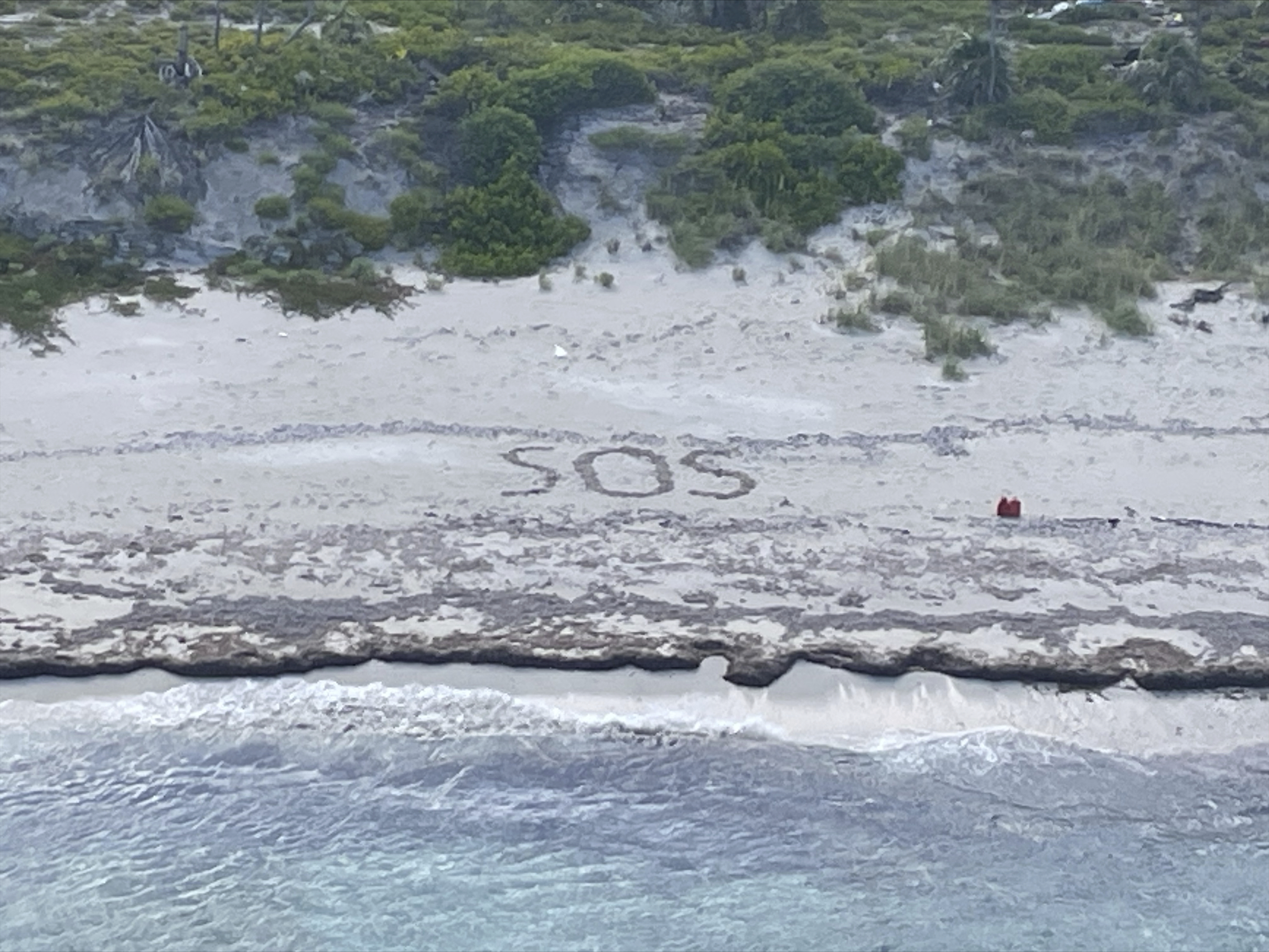 Das Foto von der US-Küstenwache zeigt die Buchstaben „SOS“, die der 64-jährige Schiffbrüchige in den Sand malte.