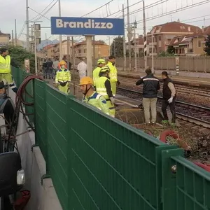 Einsatzkräfte und Ermittler stehen an Bahngleisen in Brandizzo.