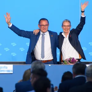 Tino Chrupalla und Alice Weidel jubeln über die Annahme des Wahlprogramms für die Europawahl und winken den Delegierten zu.
