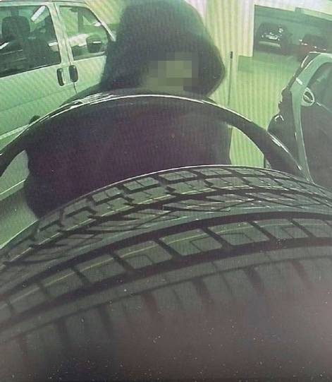 Ein Täter klaut die Reifen eines Autos.