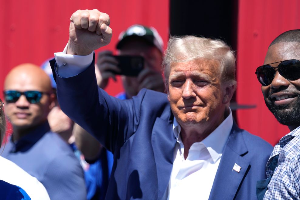 Donald Trump reckt bei einer Veranstaltung seinen rechten Arm mit geballter Faust in die Höhe.