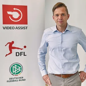 Videobeweis-Chef Jochen Drees vor dem VAR-Logo