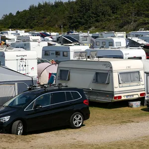 Zahlreiche Wohnwagen stehen auf einem Campingplatz in Strandnähe. (Symbolbild)