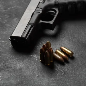 Patronen liegen neben einer Schusswaffe.