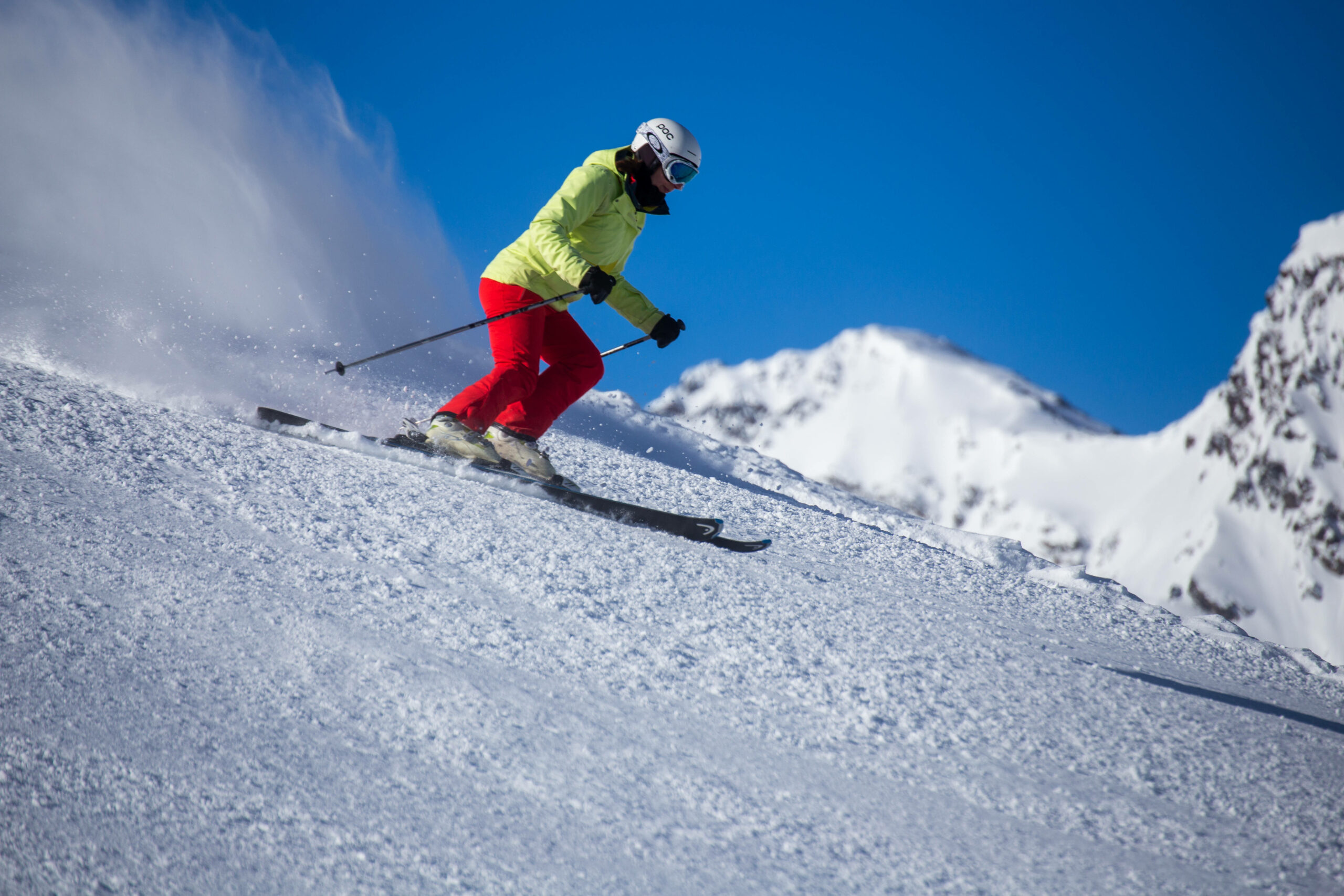 Eine Skifahrerin fährt einen Hang hinunter.