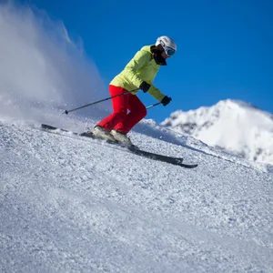 Eine Skifahrerin fährt einen Hang hinunter.