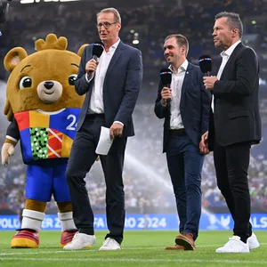Moderator Florian König (links) stellt zusammen mit Philipp Lahm und Lothar Matthäus das Maskottchen für die EM 2024 vor