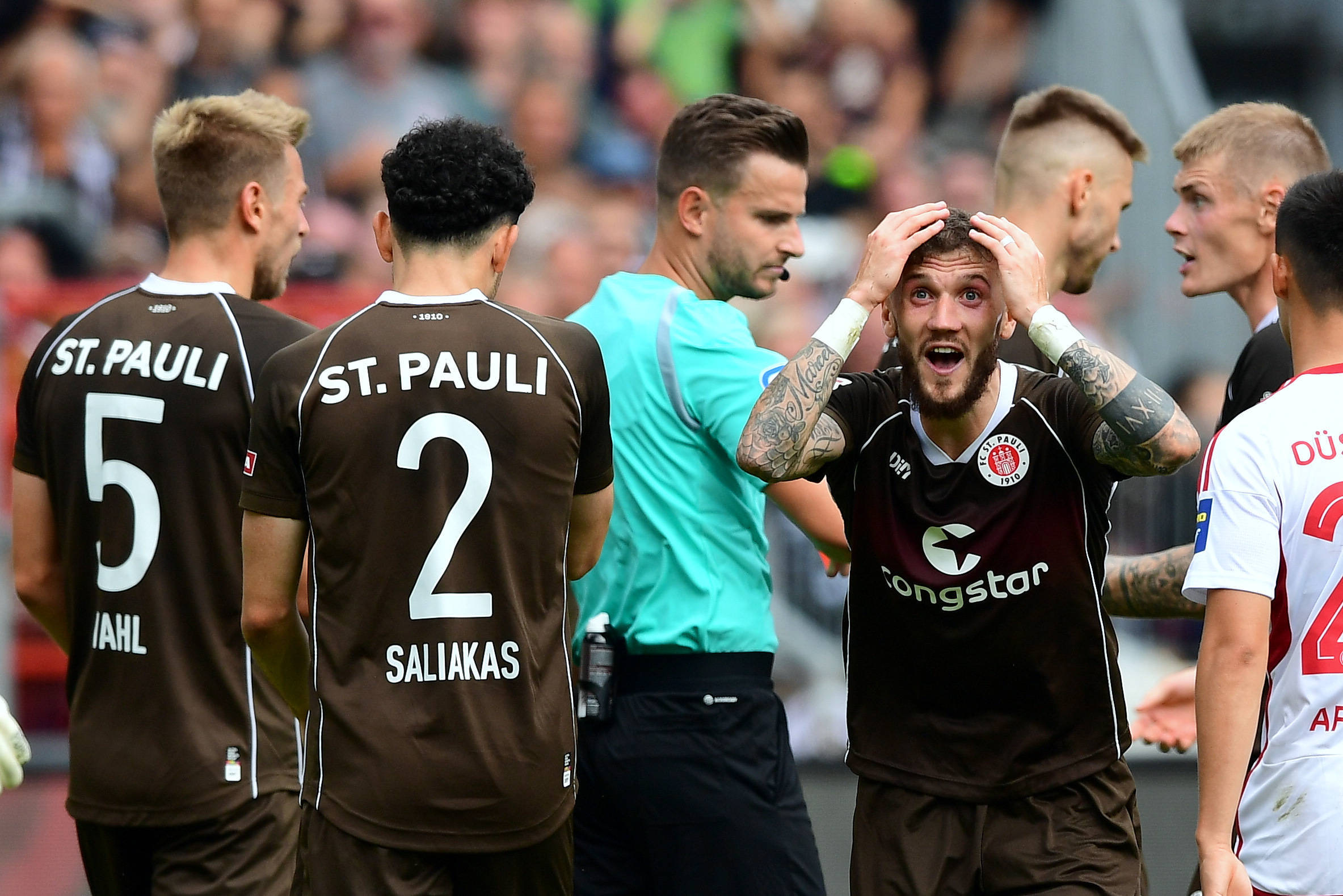 Schiedsrichter Daniel Schlager umringt von St. Pauli-Spielern