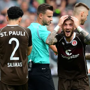 Schiedsrichter Daniel Schlager umringt von St. Pauli-Spielern