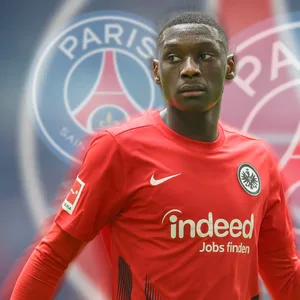 Der Frankfurter Randal Kolo Muani vor mehreren Wappen von Paris Saint-Germain