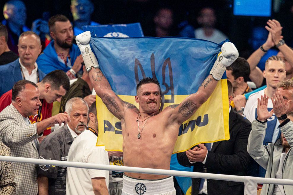 Oleksander Usyk bejubelt den verteidigten WM-Titel im Schwergewicht mit ukrainischer Flagge