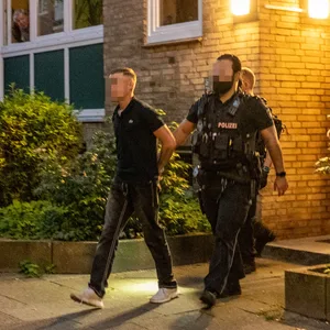 Polizisten führen den 16-Jährigen ab.
