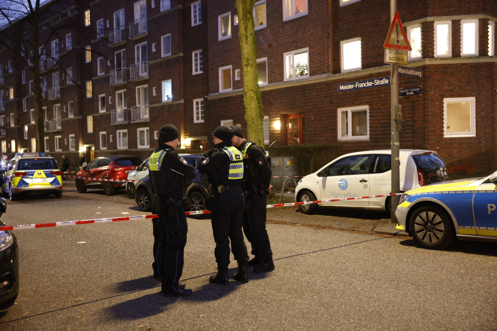 Polizeibeamte stehen nach der Messerattacke am abgesperrten Tatort.