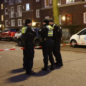 Polizeibeamte stehen nach der Messerattacke am abgesperrten Tatort.
