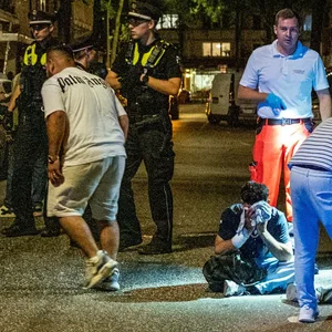 Die verletzten Männer sitzen teilweise auf dem Boden, werden von Sanitätern versorgt.
