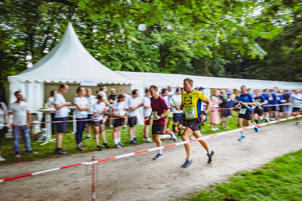 Die Route verläuft fünf Kilometer lang durch den Stadtpark – am Rand feuern Kollegen und Freunde an.