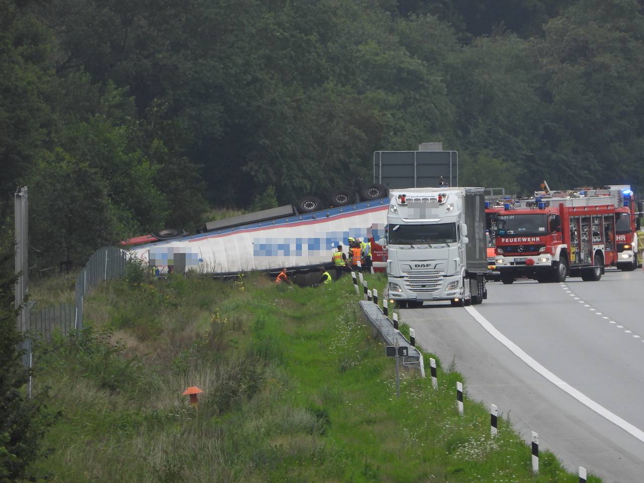 Der betroffene Laster und Rettungskräfte auf der A7.