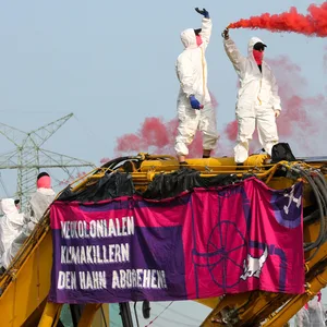 Zwei Aktivisten der Gruppe „Ende Gelände” stehen auf einem Bagger.