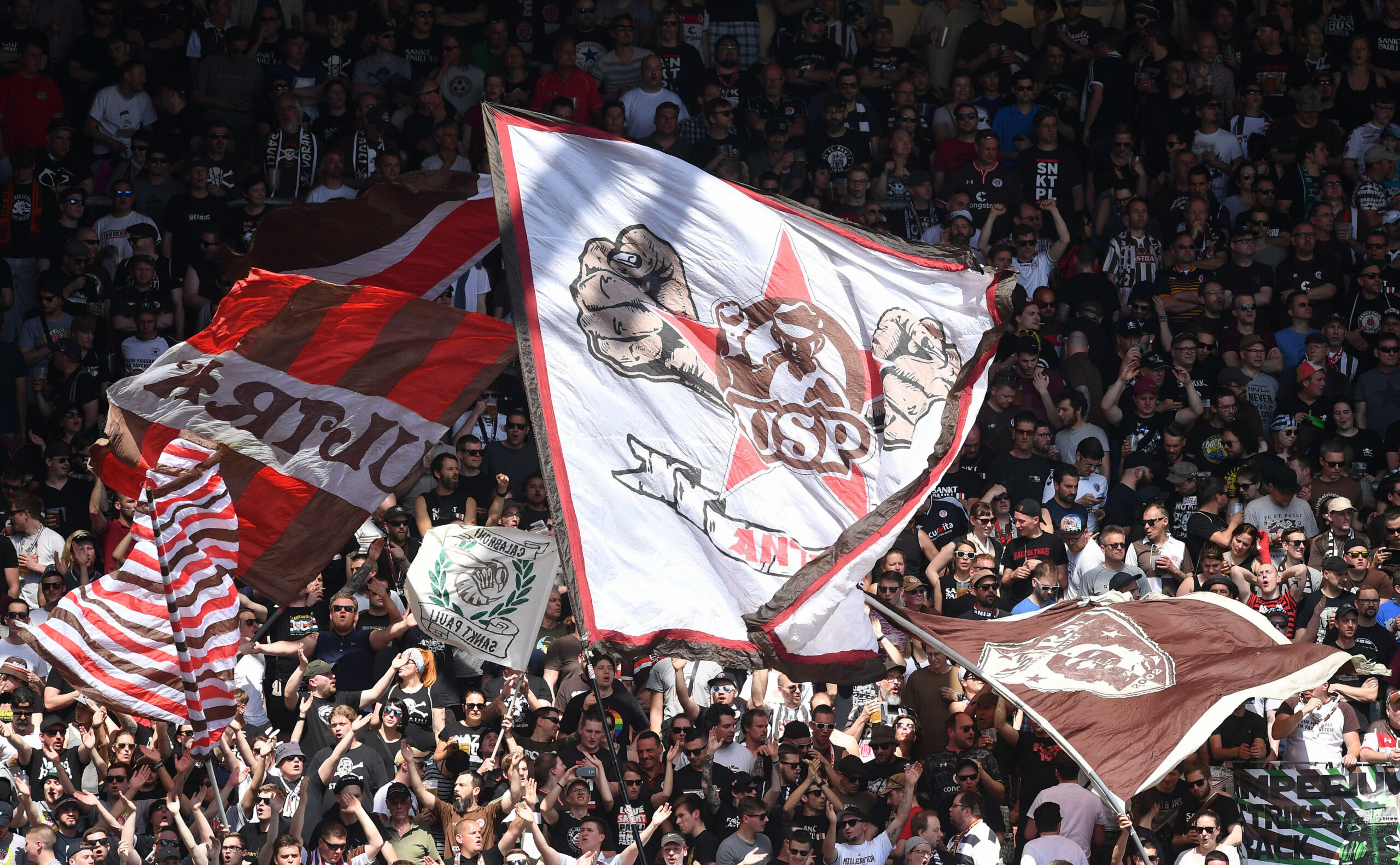 Ultras des FC St. Pauli schwenken Fahnen