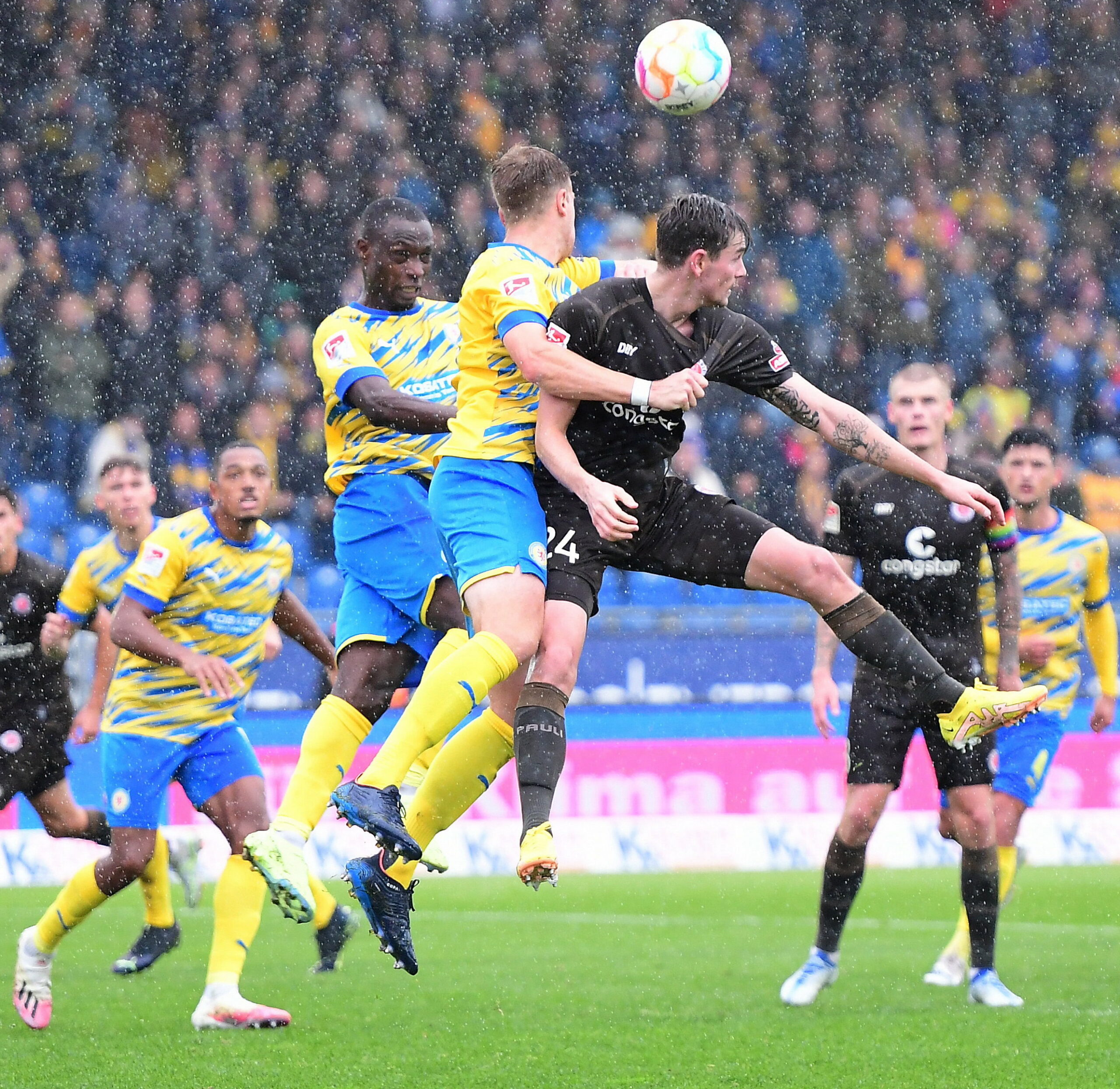 Connor Metcalfe im Kopfballduell mit Abwehrspielern von Eintracht Braunschweig.