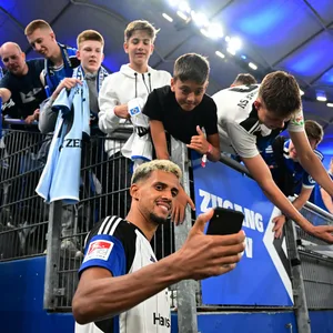 Robert Glatzel macht ein Selfie mit HSV-Fans im Volksparkstadion.