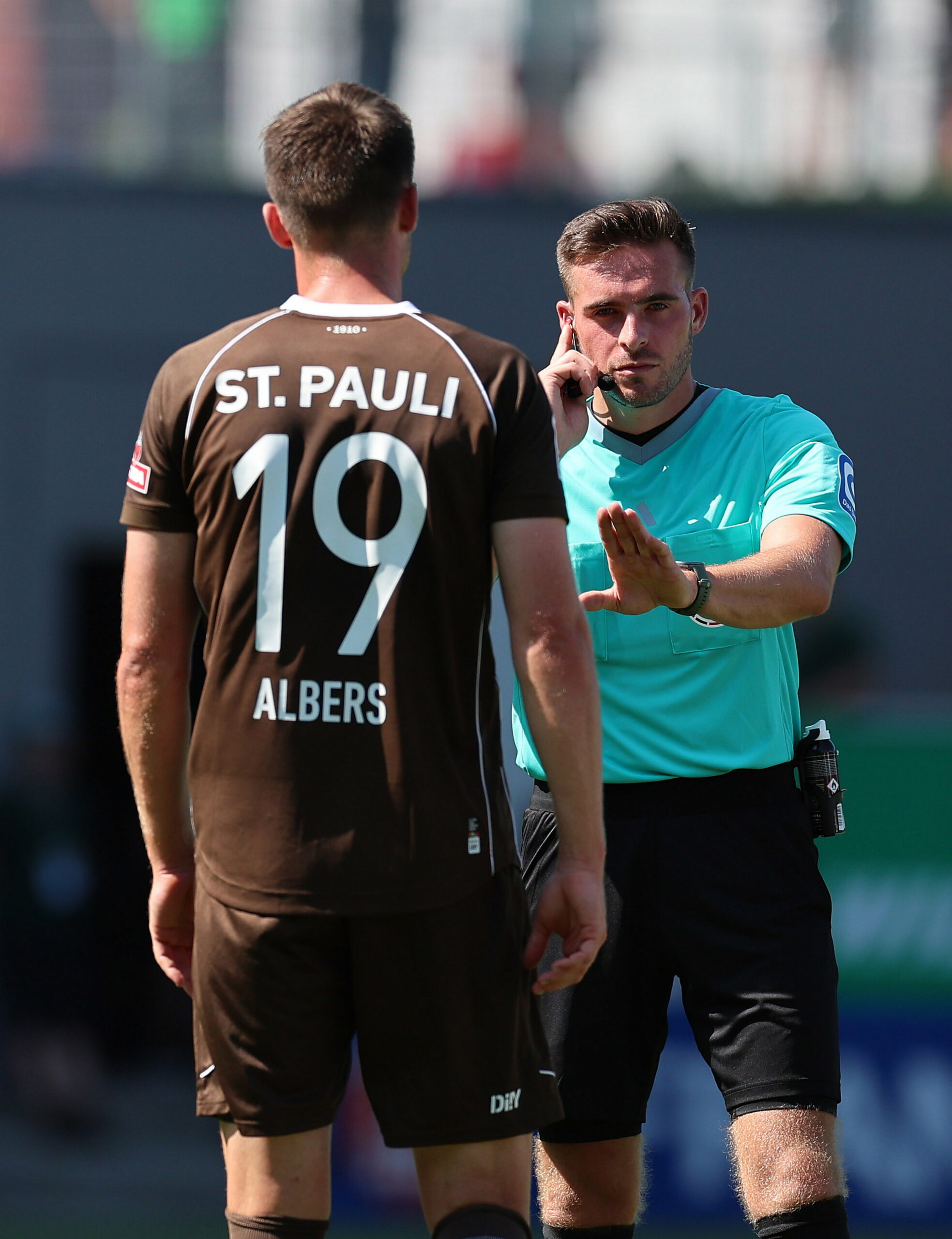 Schiedsrichter Tom Bauer mit St. Paulis Andreas Albers