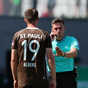 Schiedsrichter Tom Bauer mit St. Paulis Andreas Albers