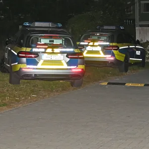 Streifen- und Rettungswagen parken vor der Flüchtlingsunterkunft.