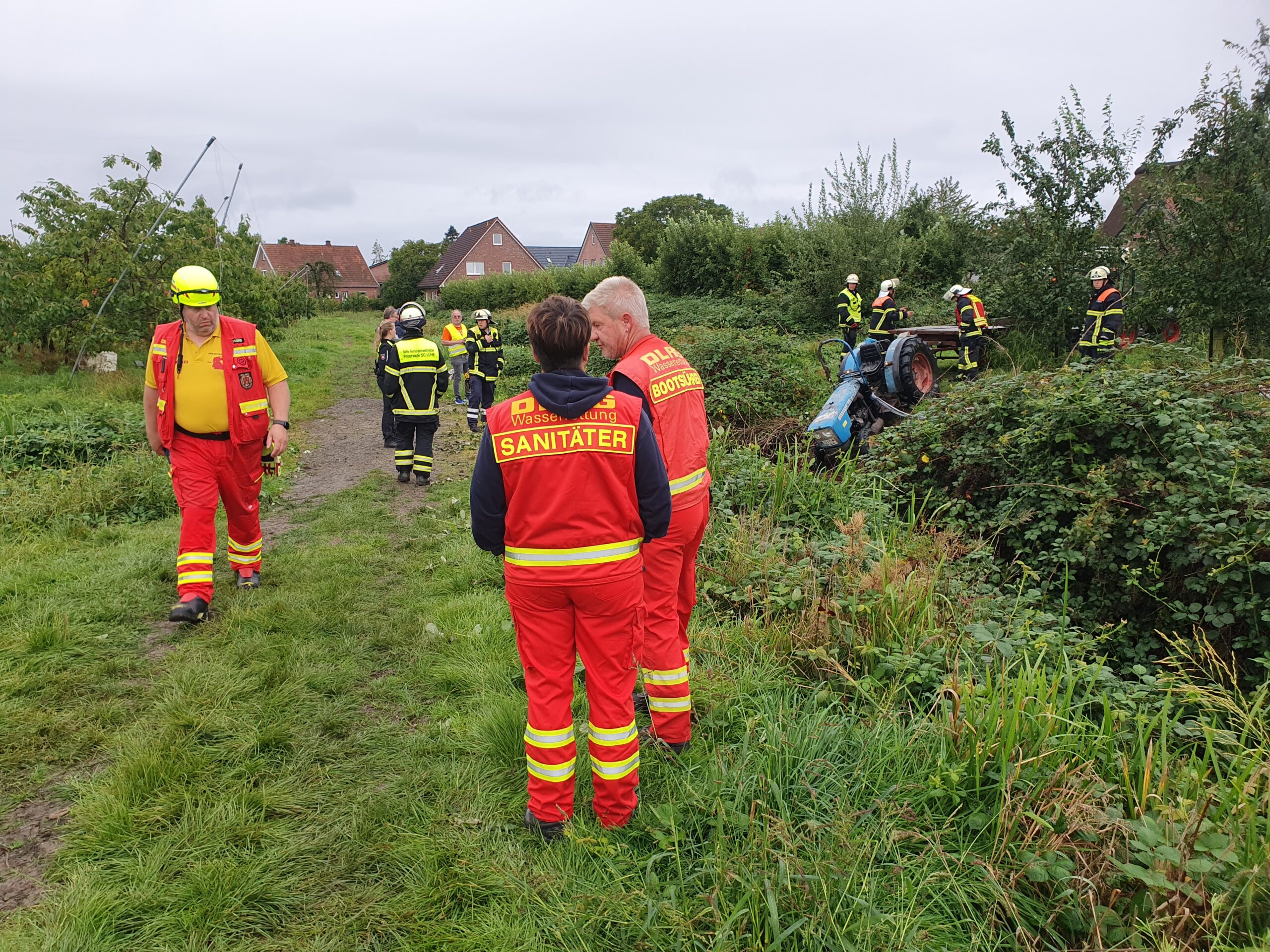 Einsatzkräfte in Jork. Im Hintergrund: der Traktor.