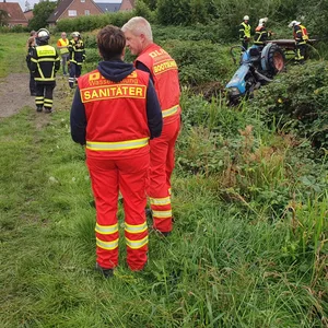 Einsatzkräfte in Jork. Im Hintergrund: der Traktor.