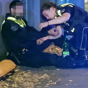 Polizistin kniet neben ihrem Kollegen